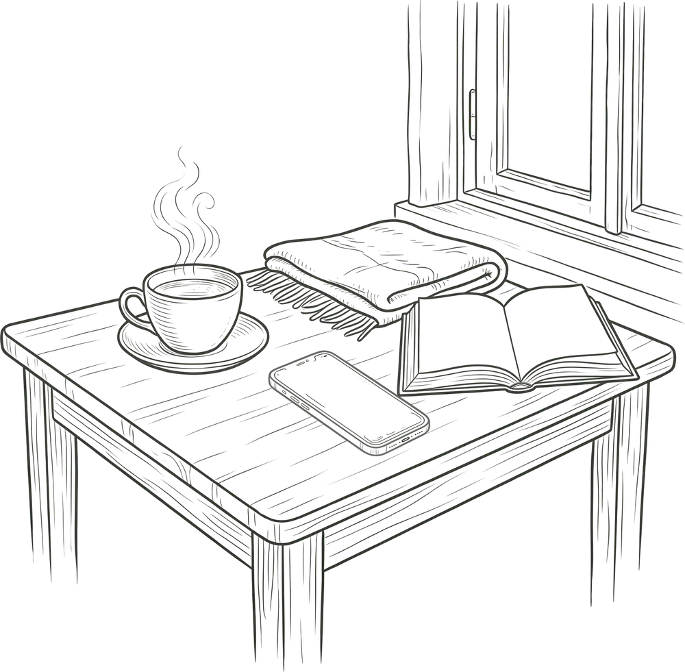 A steaming cup of tea, a folded blanket, an open book and a phone on a table by a morning window